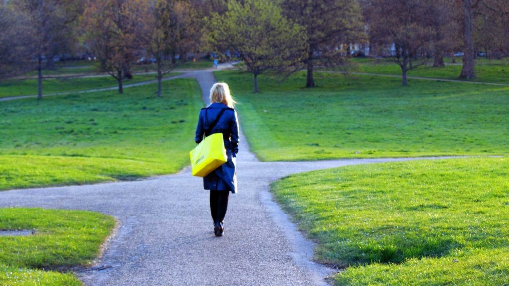 Person walking toward a forked path symbolizing choices in opioid use and recovery.