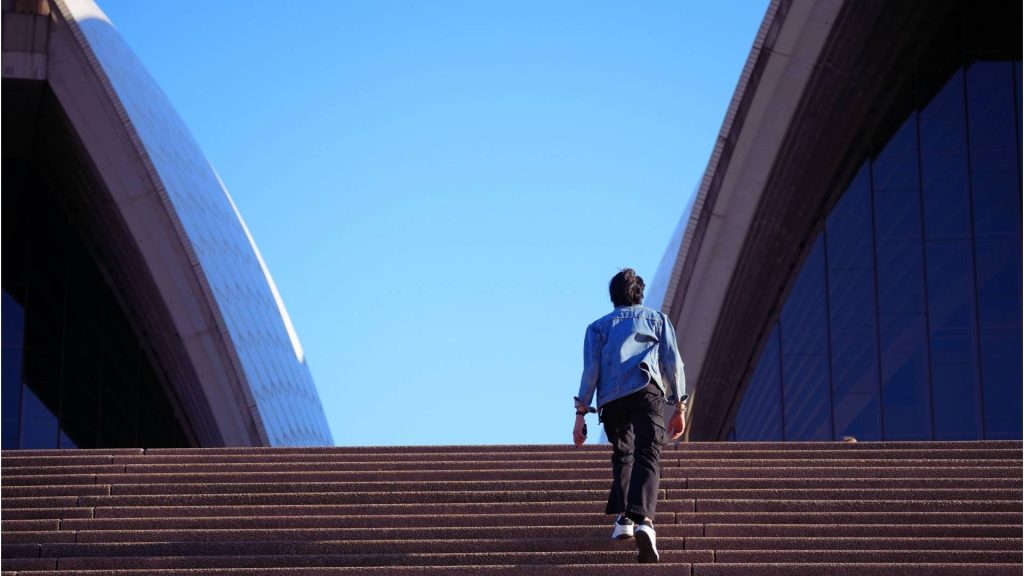 Person walking up steps toward a bright sky, symbolizing recovery after opioid relapse.